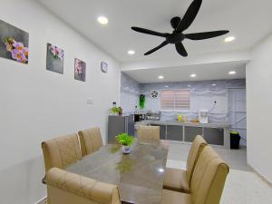 a dining room with a table and a ceiling fan at Ipoh Garden Sunway Guesthouse in Ipoh