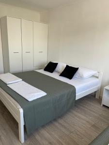 a bedroom with a large bed with white cabinets at Apartman Stipe in Neum