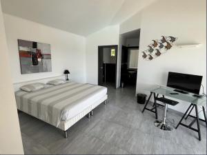 a bedroom with a bed and a desk with a computer at Padulaccia by Pinarello Villa Services in Pinarellu