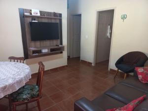 ein Wohnzimmer mit Flachbildfernseher und Couch in der Unterkunft Casa para temporada in Praia Grande