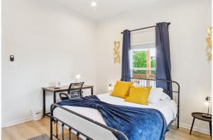 サンアントニオにある3BR-2BA Cityscape Haven with Panoramic Tower Viewの黄色い枕と窓のあるベッドのある寝室