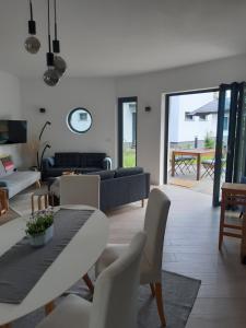 a living room with a couch and a table and chairs at Ihre Auszeit am See in Lychen