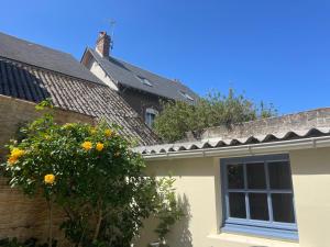 a yellow house with a tree and a window at Maison Familiale de Centre-Ville in Dives-sur-Mer