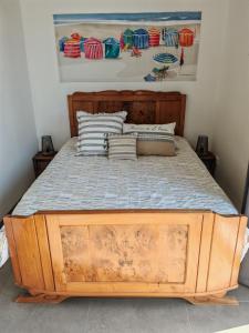 a bed with a wooden frame in a bedroom at LES BOUCHOLEURS in Yves