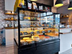 a bakery display case filled with different types of pastries at Apartment 19 - by Aquapark Reda in Reda
