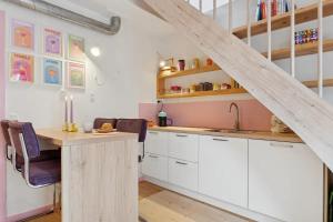a kitchen with white cabinets and a wooden table at Colorful Oasis in Viborg Centre in Viborg +8 photos