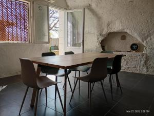 a wooden table and chairs in a room at Maison troglodytique au coeur des Châteaux de la Loire - Le Cerisier Perché in Luynes