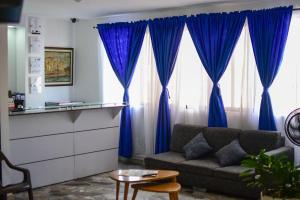 a living room with blue curtains and a couch at Hotel San Pedro in Neiva