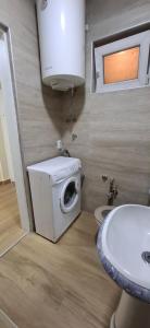 Un baño con lavadora y lavabo. en Sunčani apartman 2-Vila Amfora, en Budva