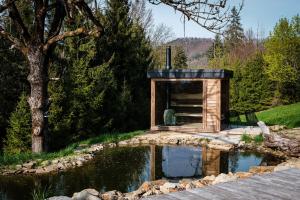 a pond in a garden with aificialificialificialificialificialificialificialificialificial at Chata Pytlorka Beskydy offgrid wellness in Zahŭří