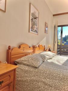 a bedroom with a bed and a desk and a window at Mountain Chalet Tre Marie in Cavalese
