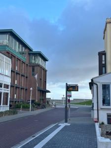 an empty street with a building and a street sign at Ferienstube Norderney in Norderney