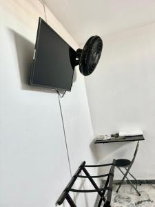 a television on a wall in a room with a chair at Hotel San Pedro in Neiva +10 photos