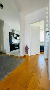 ein Wohnzimmer mit weißen Wänden und Holzböden in der Unterkunft Apartament w Centrum in Przemyśl + 4 Fotos