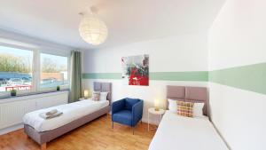 a bedroom with two beds and a blue chair at Berner Bude 5, 3SZ, 6P, TV, Wlan in Hamburg