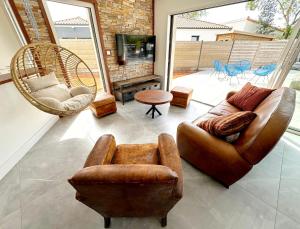 a living room with a leather couch and chairs at Villa et Spa in Pornic