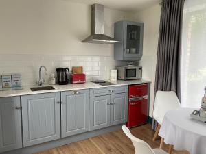 a kitchen with white cabinets and a red appliance at Riverbank Studios in Westport