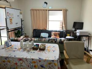 a living room with a table and a couch at ゆずハウス in Chofu +2 photos