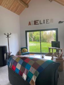 a bedroom with a bed and a large window with aeline sign at Gîte L'Atelier d'Emile in Baigneux-les-Juifs