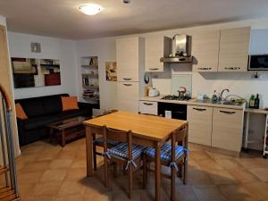 a kitchen and living room with a table and a couch at LA CASA DI MARIO in Perledo