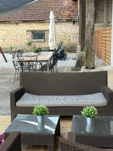 un patio con tavolo, sedie e un divano di The charming private Farmhouse at La Grenouillére a Puyréaux