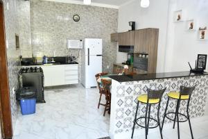 a kitchen with a counter and stools in it at Pousada Bem-te-vi in Aracaju