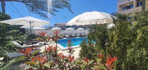 a swimming pool with umbrellas and chairs and a swimming pool at Vila EPIC in Costinesti