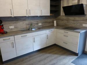 a kitchen with white cabinets and a sink at Barbara und Walter in Hottenbach