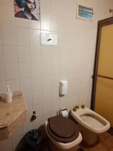 a bathroom with a toilet with a black lid at Pousada elisa in Cordoba +53 photos