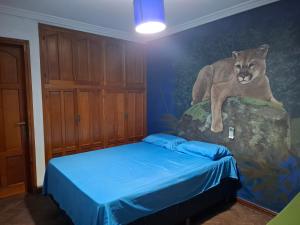 a bedroom with a lion painted on the wall at Pousada elisa in Cordoba