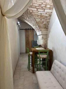 a dining room with a table and green chairs at 17 per 2 in Martina Franca