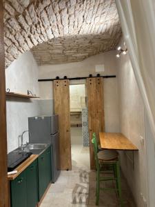 a kitchen with green cabinets and a wooden table at 17 per 2 in Martina Franca +14 photos