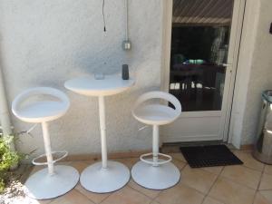 three white stools sitting in front of a door at T1 bis indépendant dans maison individuelle in Albi