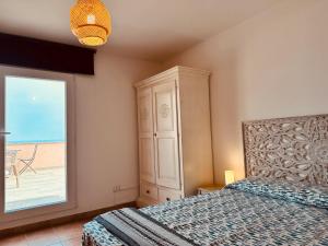 a bedroom with a bed and a large window at Attico La Terrazza sul Mare in Cagliari