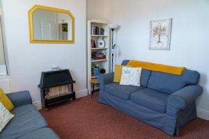a living room with a blue couch and a mirror at George Street Beverley in Beverley
