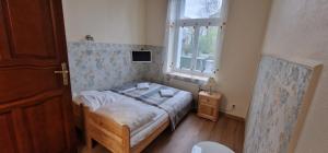 a small bedroom with a bed and a window at Sopot Roza Apartments in Sopot