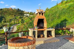 an outdoor pizza oven with a brick fireplace at EL RANCHITO, Playa a 15 min, Piscina, BBQ, Chimenea, Vistas, Terraza, Aparcamiento in Torrox
