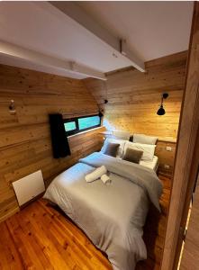 a bedroom with a large bed in a wooden wall at Le 36 Chalet 6 pers Le Mont-Dore Sauna Ski Hiking in Mont-Dore