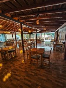 a dining room with wooden tables and chairs at Hotel Carmen del Parana in Carmen del Paraná