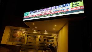 un cartello in cima a un edificio con un cartello di The Bunkk Inn Hotel & Restaurant a Mussoorie