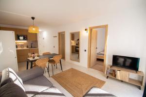 a living room with a couch and a table with chairs at Casa Luminaria in Costa Del Silencio