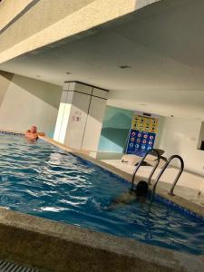 a man swimming in a swimming pool at Cityscape Grand Tower Condo, studio unit in Cebu City
