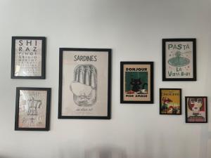 a group of framed pictures on a wall at La Maison du cadre in Bergues