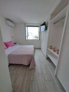 伊斯基亚Casa Iayo的一间带床和窗户的白色卧室