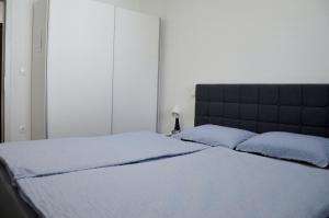 a bed with two blue pillows in a bedroom at Apartmaji Baznik Čatež in Brežice