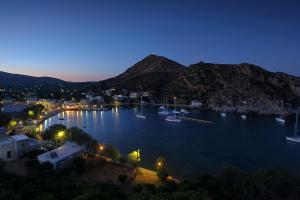 a view of a harbor at night with boats in the water at MASTIHA SeaSide Emporios Apartments in Emporeios