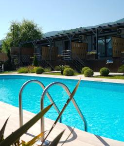 a blue swimming pool with a building in the background at Golyaka Stone Garden Hotel in Orhangazi