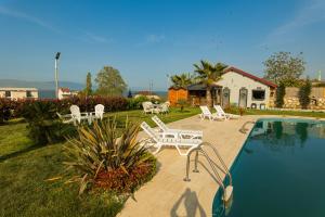 a backyard with a pool and chairs and a house at Golyaka Stone Garden Hotel in Orhangazi
