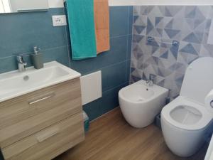 a bathroom with a white sink and a toilet at Dentro Scopello - Casa Vacanze in Scopello