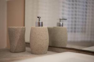 a bathroom with three soap dispensers in front of a mirror at Peaceful Hub Saturnia in Manciano
